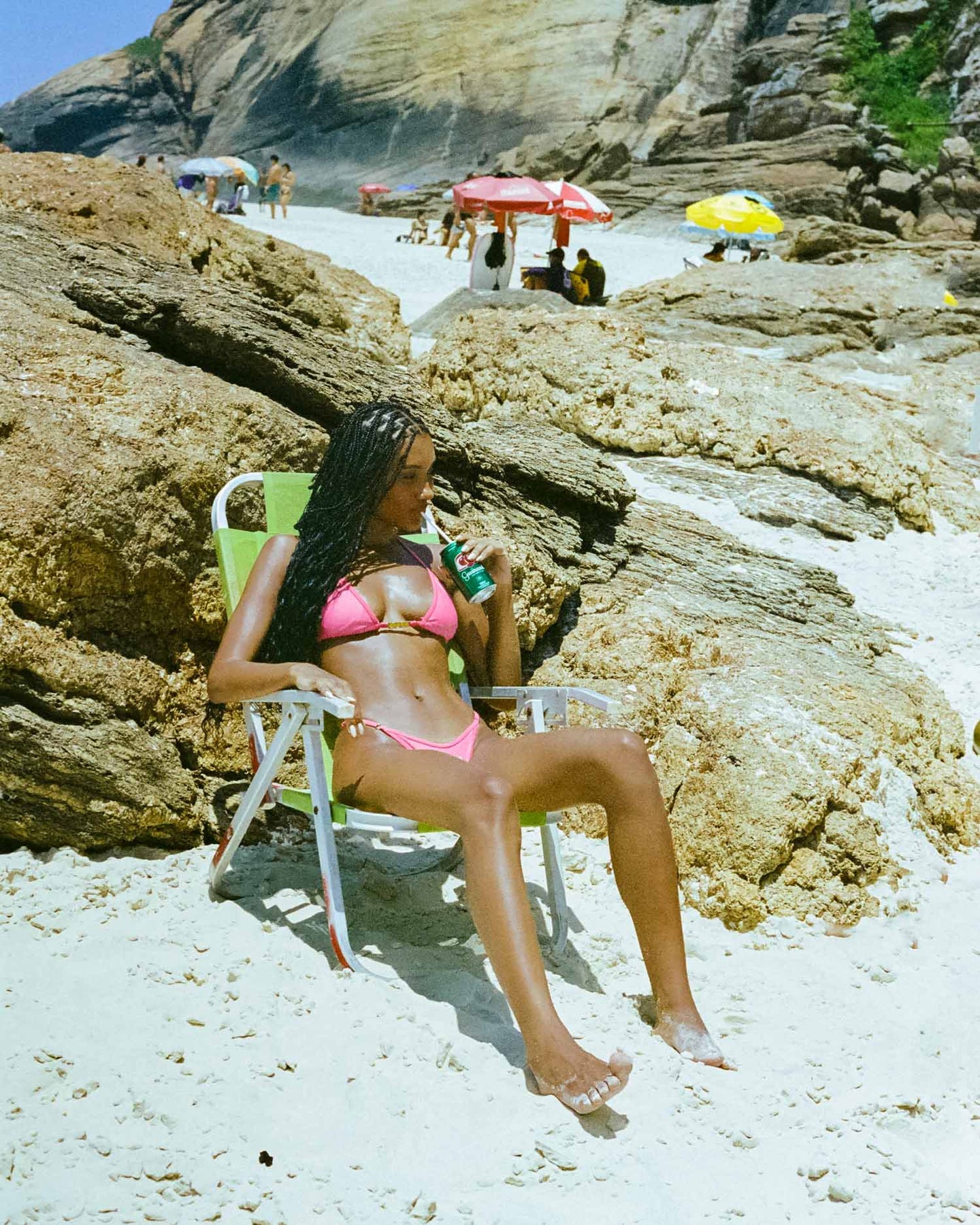 In a chic pink color, a model flaunts a bikini with a high-waisted thong design and adjustable sides, creating a delightful and stylish summer bikini look.