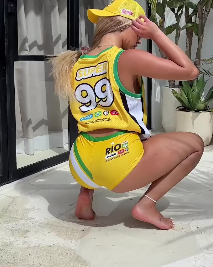 Model showcasing 360-degree view of vibrant yellow athletic shorts with green waistline Brazilian-inspired graphics.