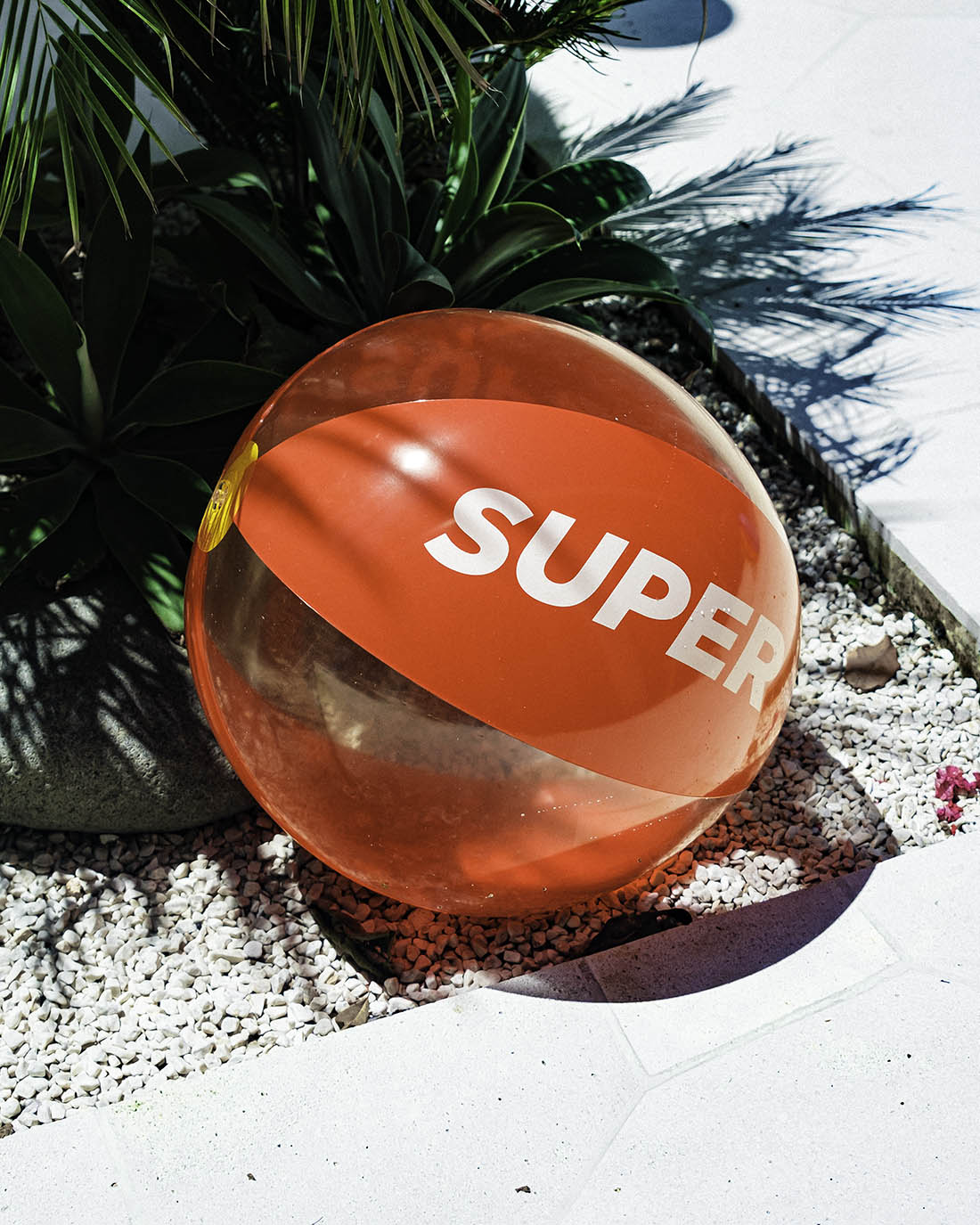 Beach ball with solid red and clear design.