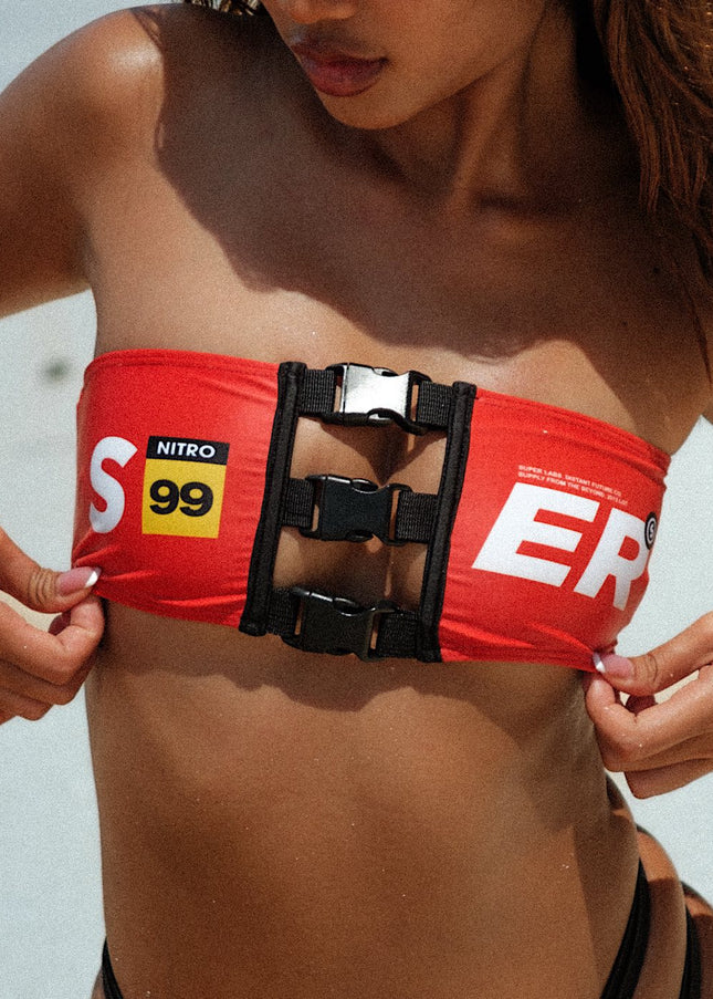 Super close up shot of the model showcasing a cute red bandeau top with clips, emphasizing intricate details for a stylish and secure fit.