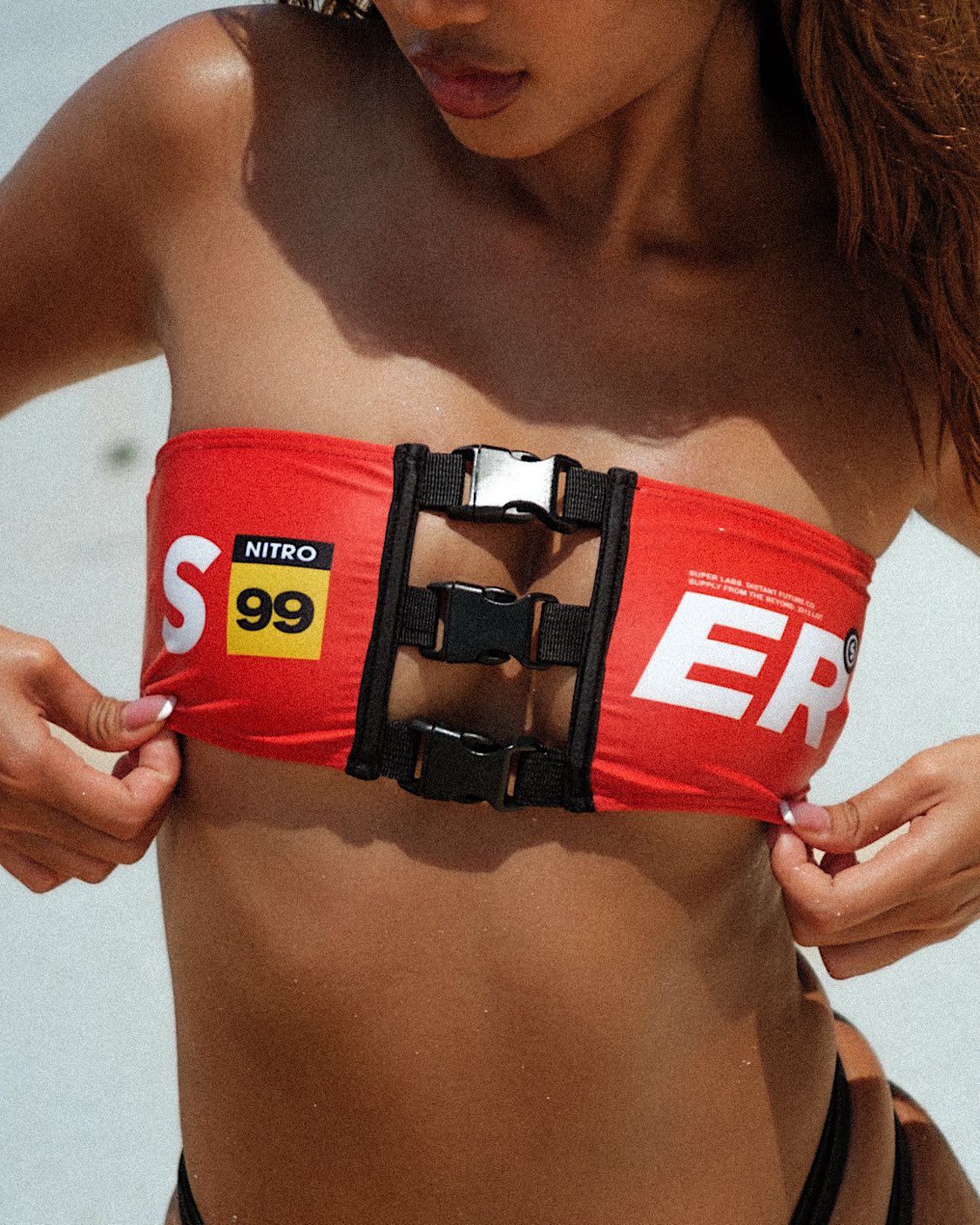 Super close up shot of the model showcasing a cute red bandeau top with clips, emphasizing intricate details for a stylish and secure fit.