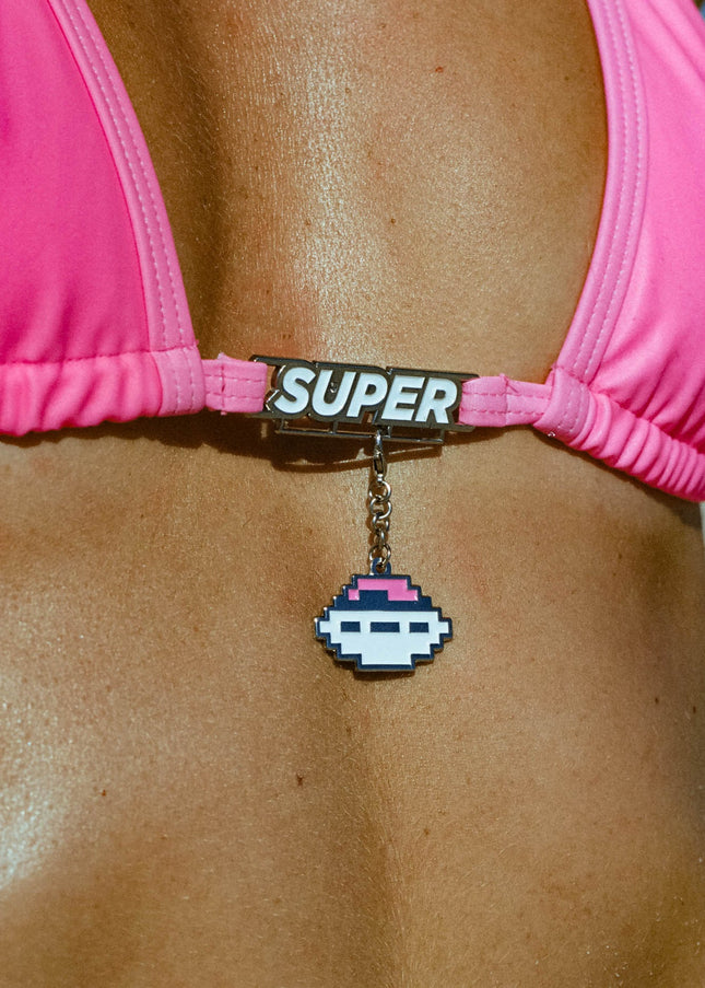 Super close-up shot highlighting the charm bar and accessory detail on the top of a model in a Triangle Design High Waisted Premium High Shot Pink Thong Bikini with adjustable sides and a Super buckle embellishment accessory on the rear.