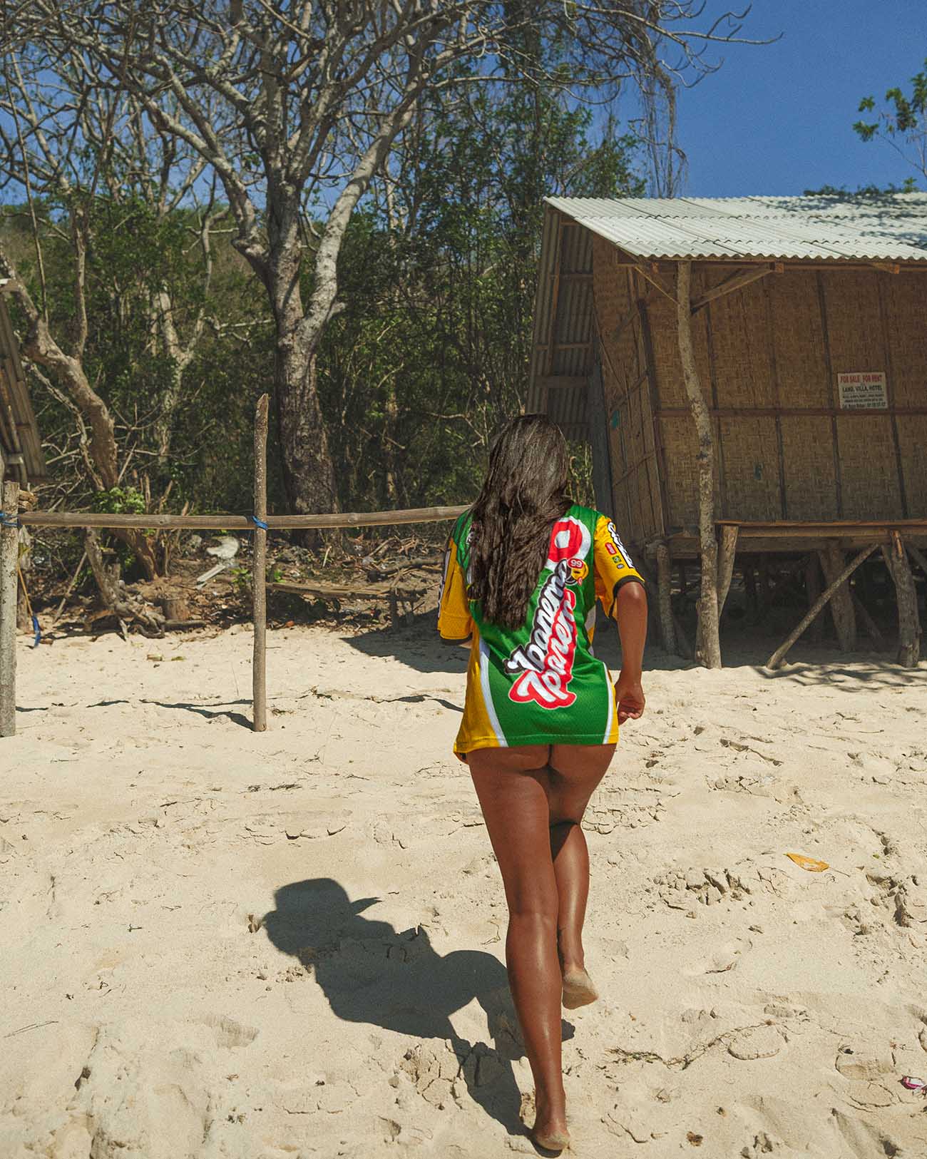 Woman wearing Ipanema oversized jersey on a beach, showcasing summer casual style and breathable mesh fabric.