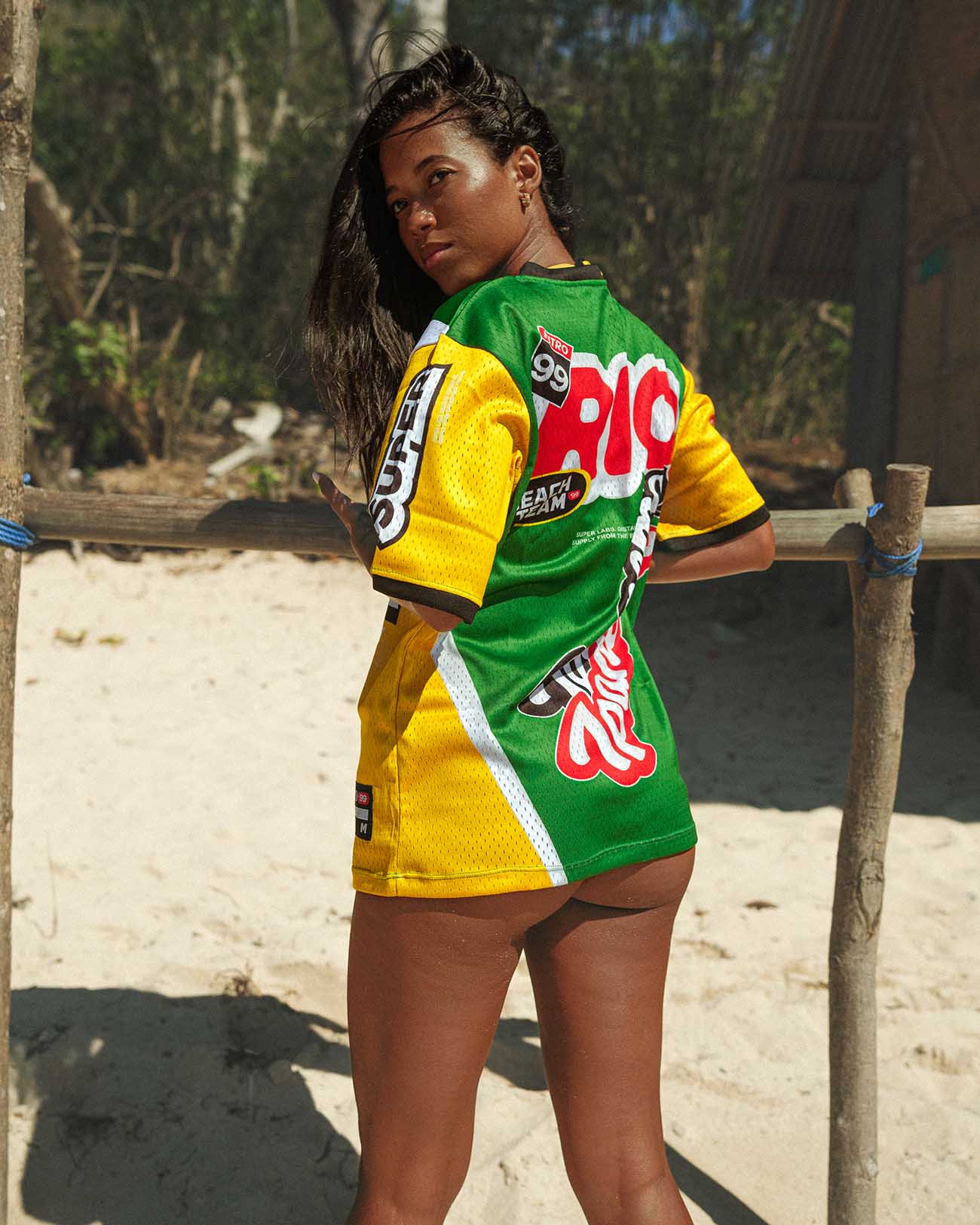 Model wearing Ipanema oversized jersey in vibrant colors, showcasing breathable mesh fabric on a sunny beach.