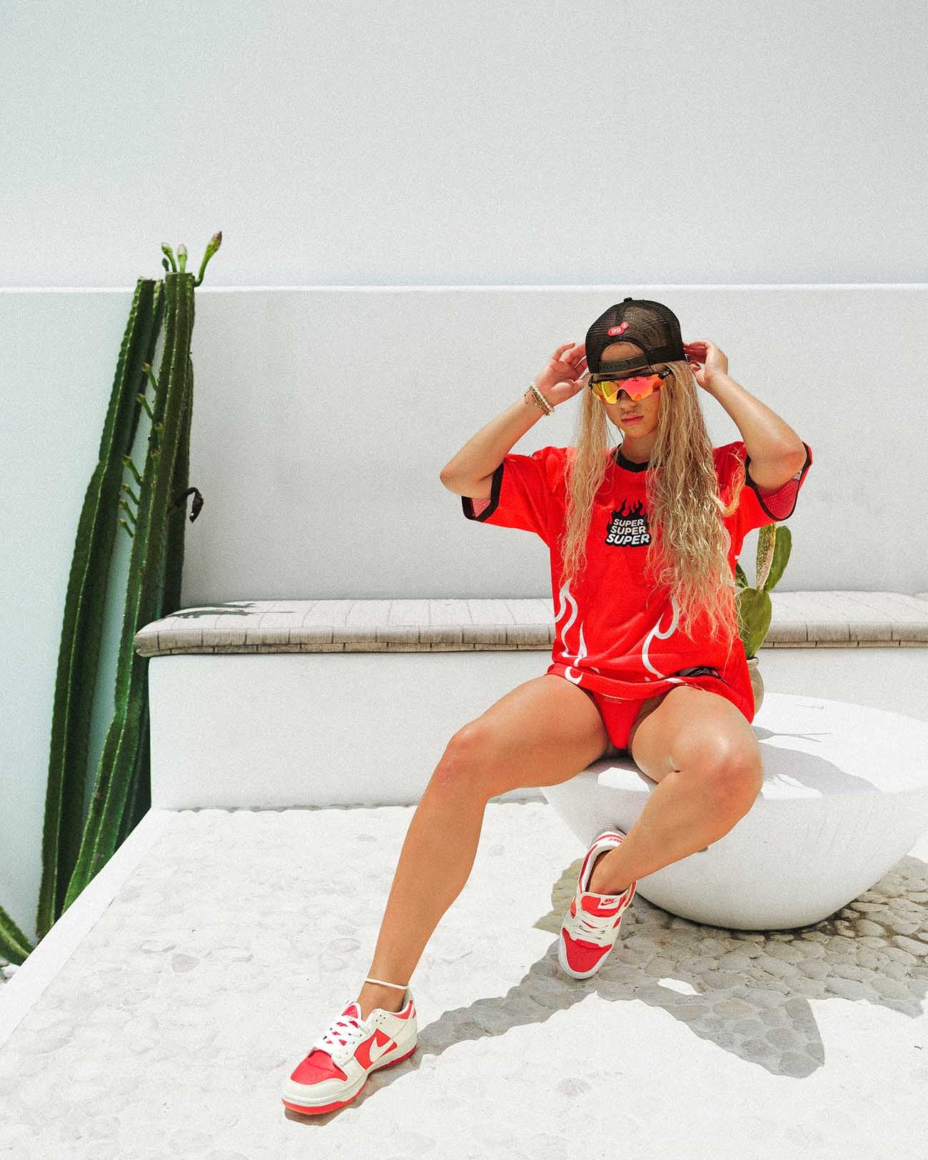 Model wearing oversized red heat jersey with breathable fabric, styled for summer activities and street fashion.