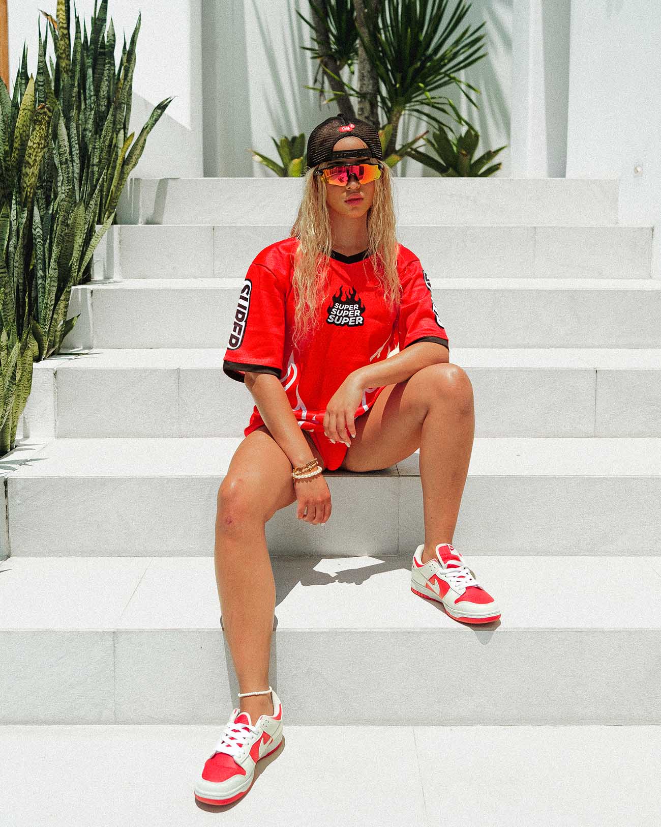 Model wearing oversized red Heat jersey with cooling perforations, perfect for summer street style.