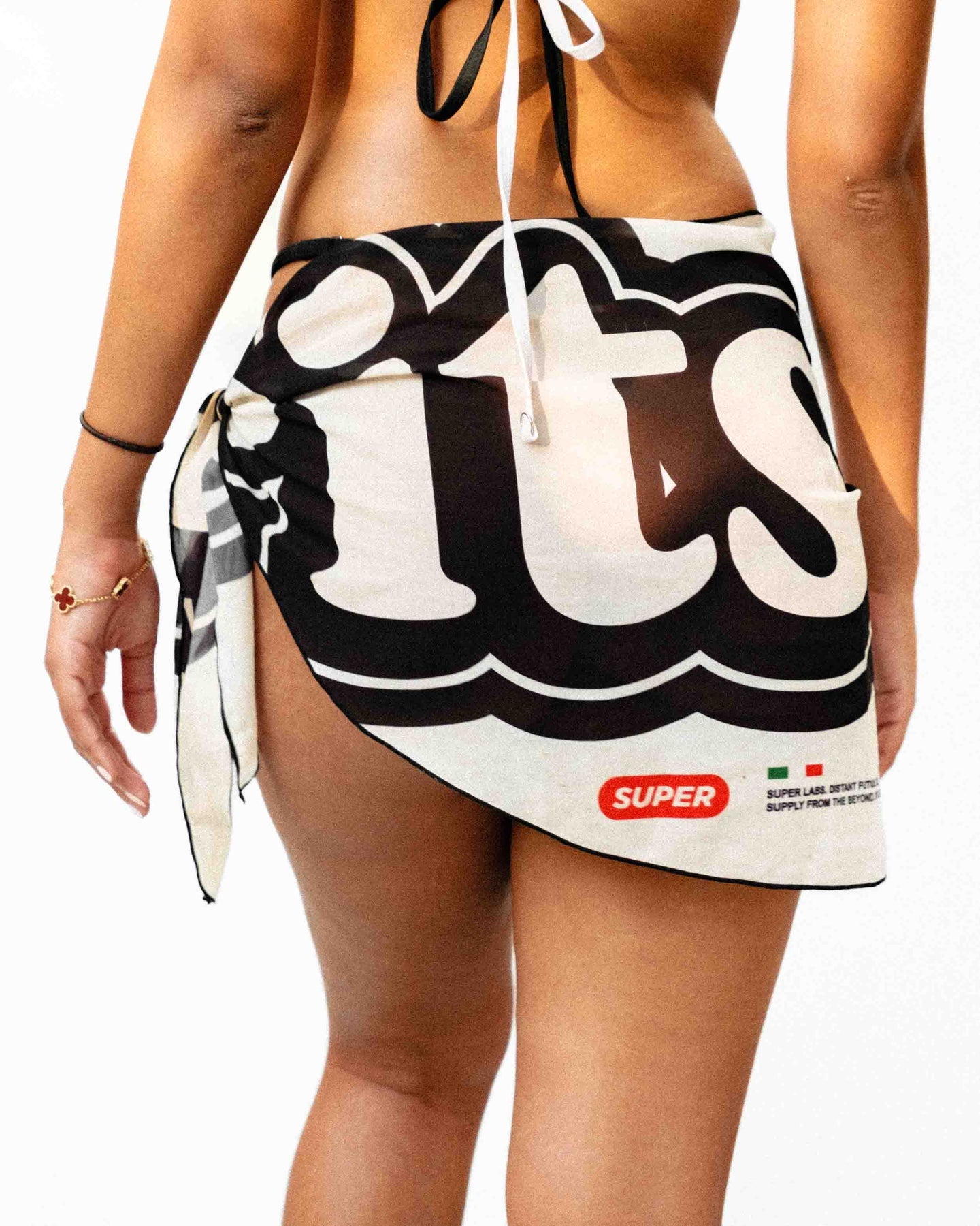 From the rear view model is showcasing a beautiful light weight white and black sarong.