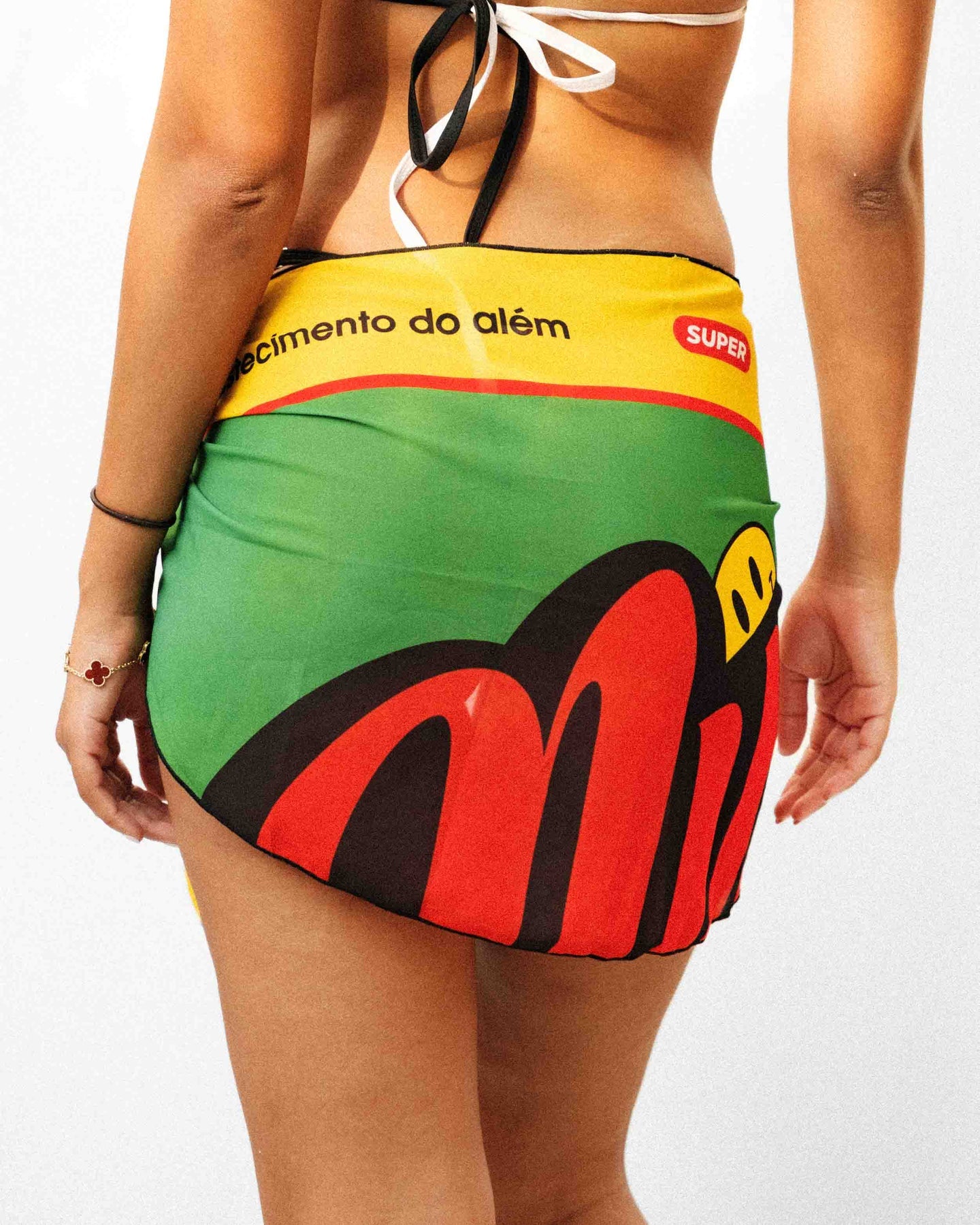 Close up rear view shot of a model showcasing a beautiful light weight black yellow and green Rio inspired sarong.