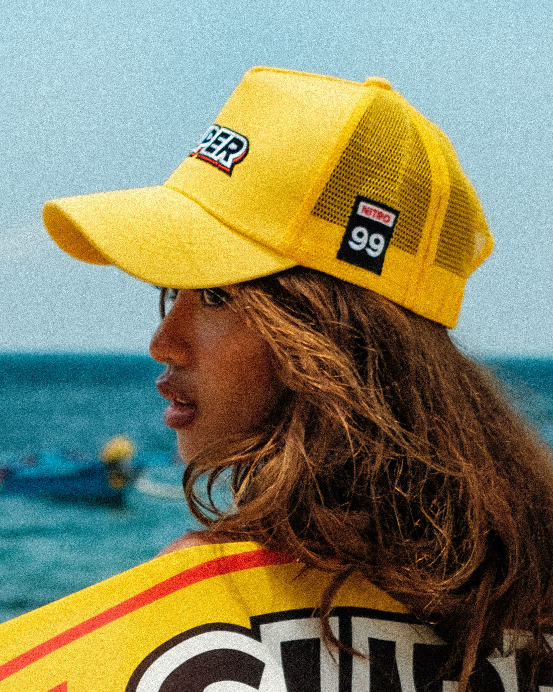 Close up short of a model rocking a super yellow mesh snapback hat with stylish patches.