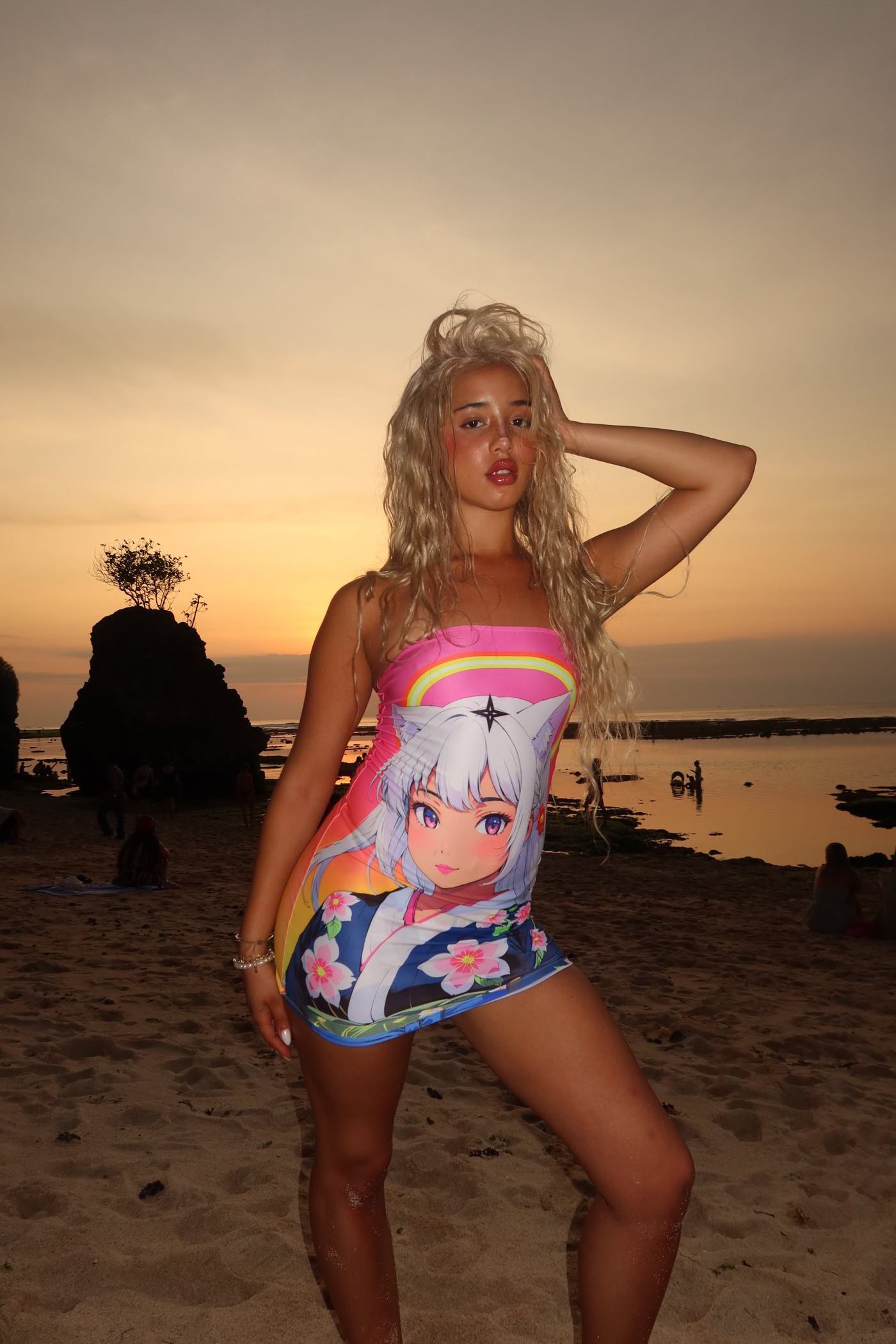 Woman wearing a Kimono Tube Dress with anime girl design at beach during sunset, showcasing pink ombre colors and versatile style.