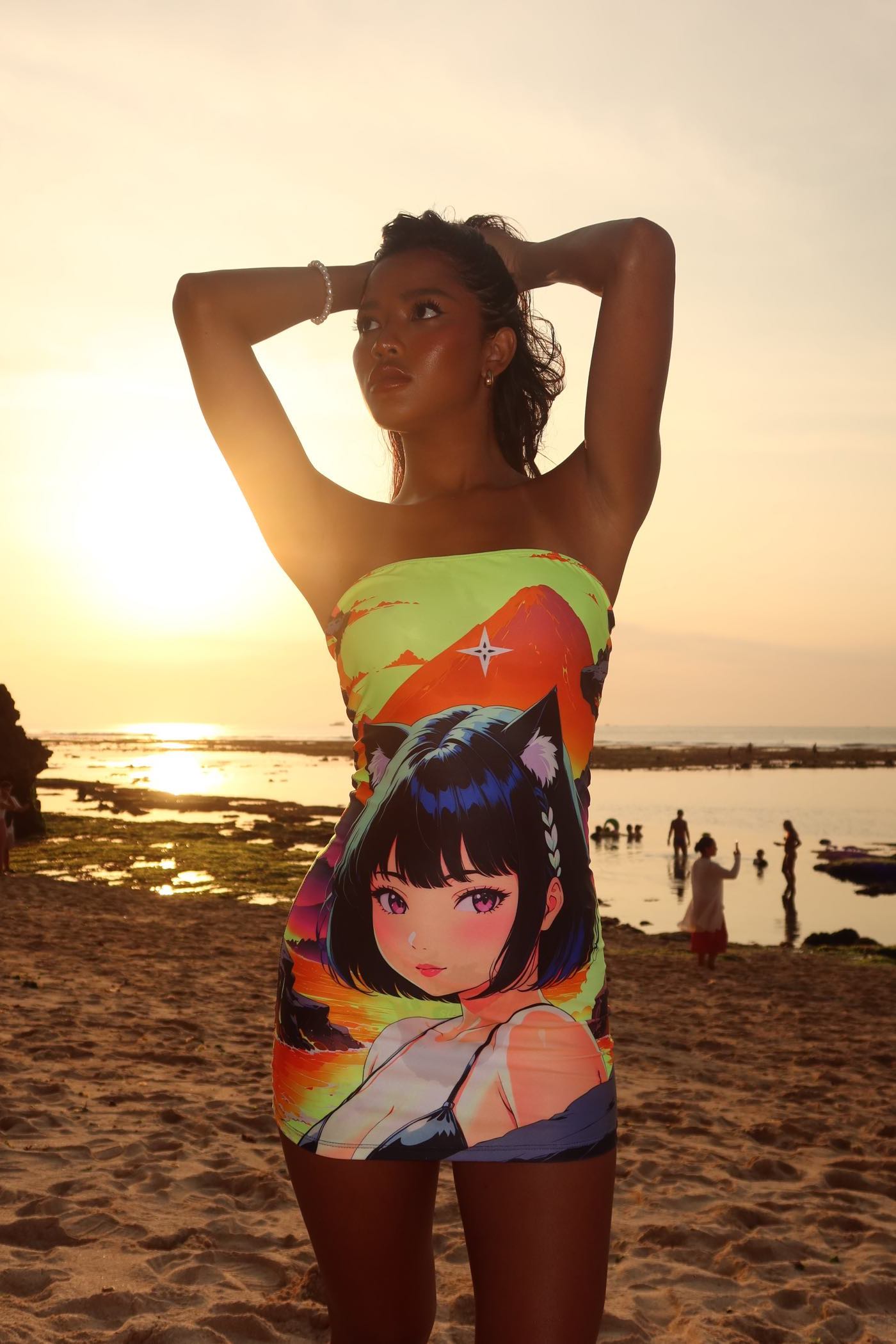 Woman wearing Volcanic Tube Dress with anime girl design on a beach at sunset.